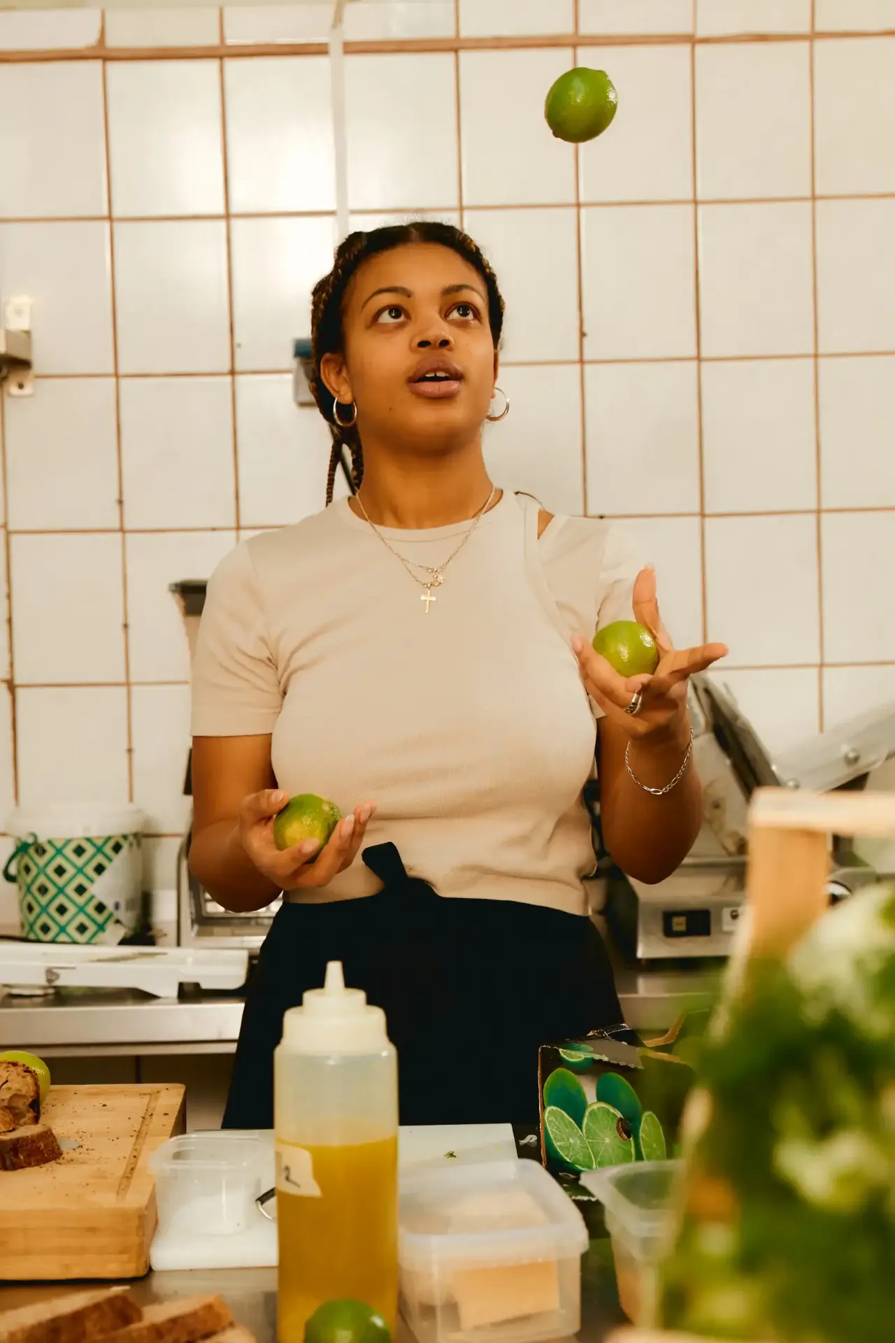 Woman juggling limes in a kitchen