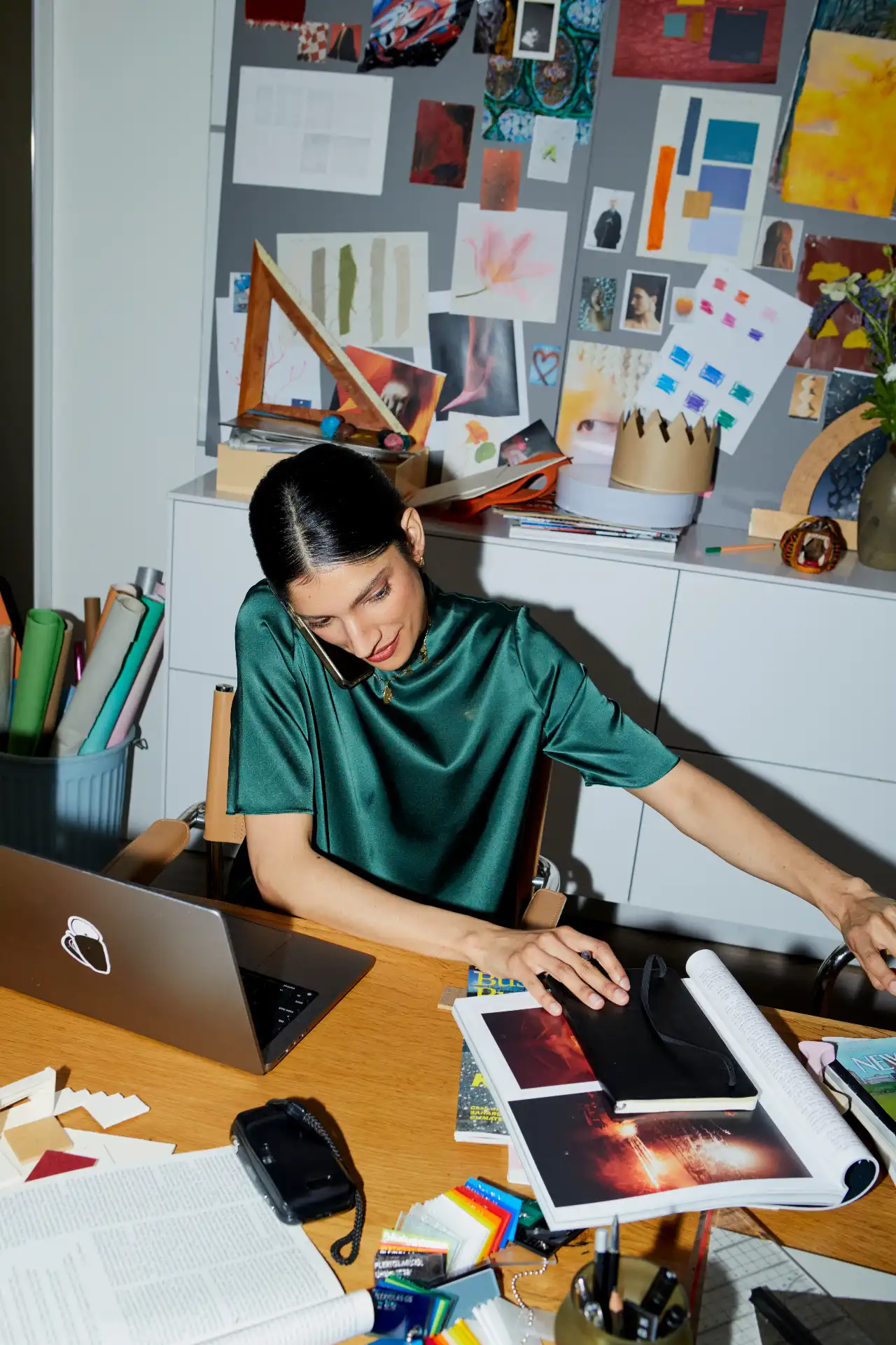 Woman in green working at her studio desk